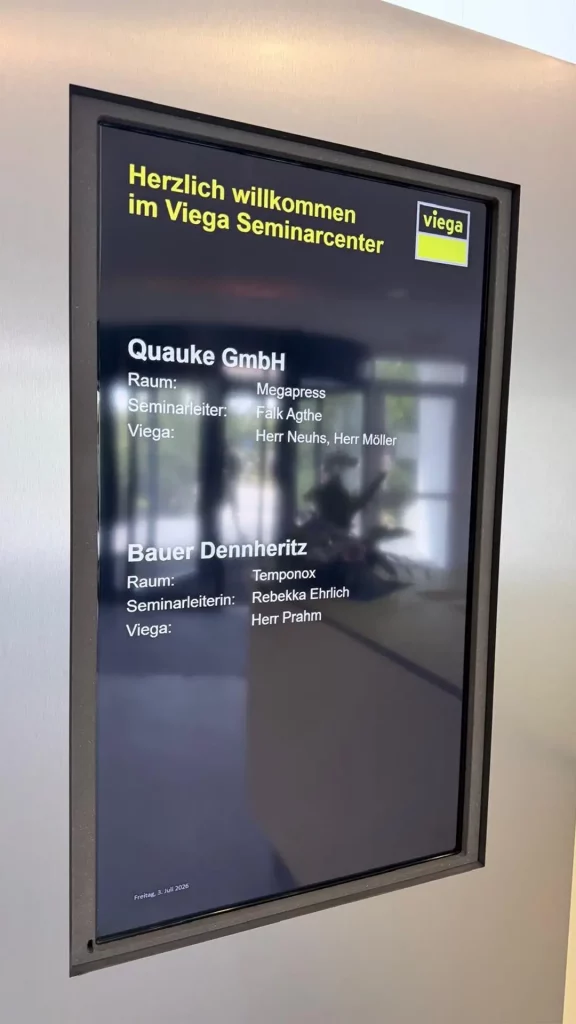 Digitales Willkommensdisplay im Viega Seminarcenter mit der Begrüßung der Quauke GmbH zum Seminar.
