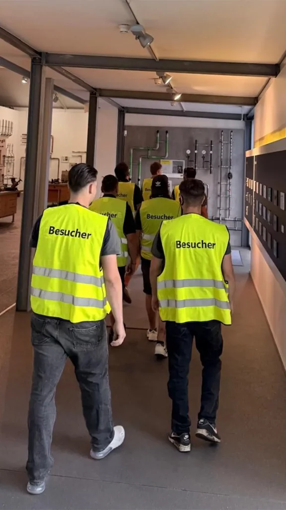Mitarbeitende der Quauke GmbH mit Besucherwesten während einer Führung durch das Viega Seminarcenter.