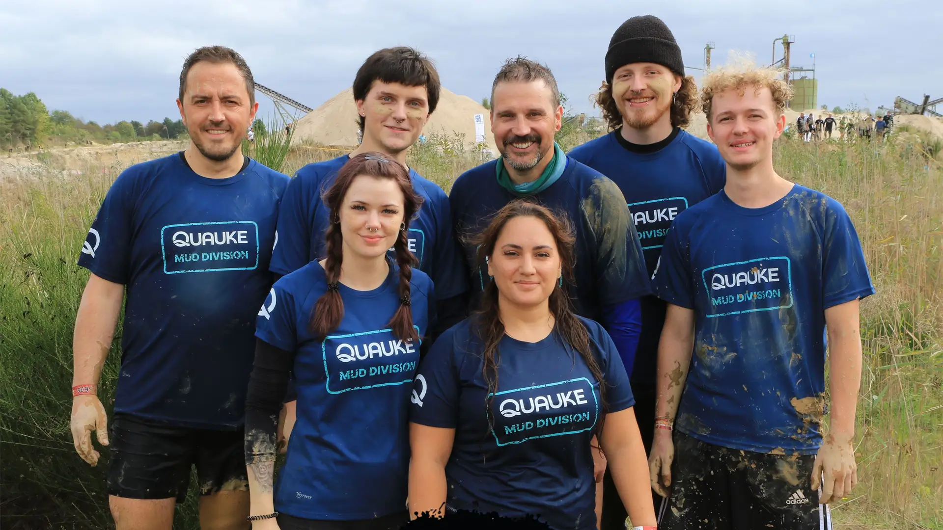 Gruppenfoto des Quauke-Teams in „Mud Division“-Shirts nach der Teilnahme am Mud Masters. Teilnehmer des Q