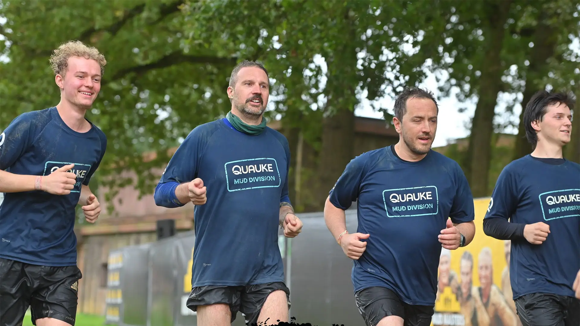 Vier Mitglieder des Quauke-Teams laufen gemeinsam eine Strecke beim Mud Masters.